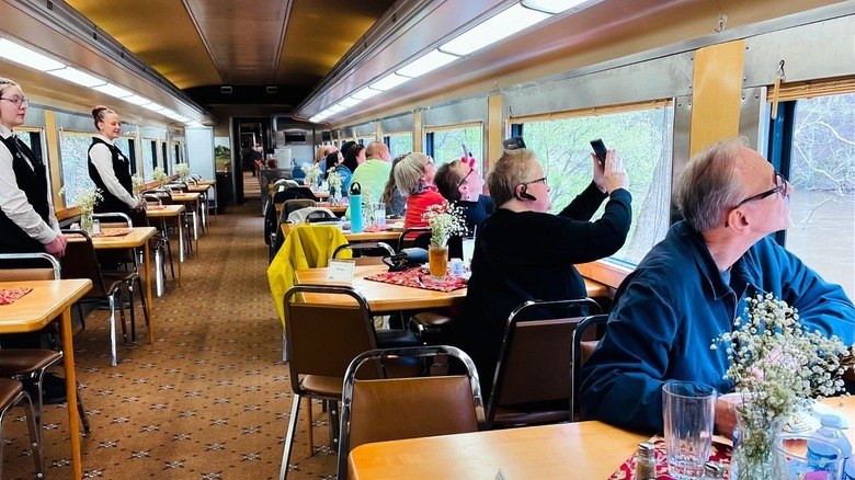 Travelers gazing outside of windows in the dining cart