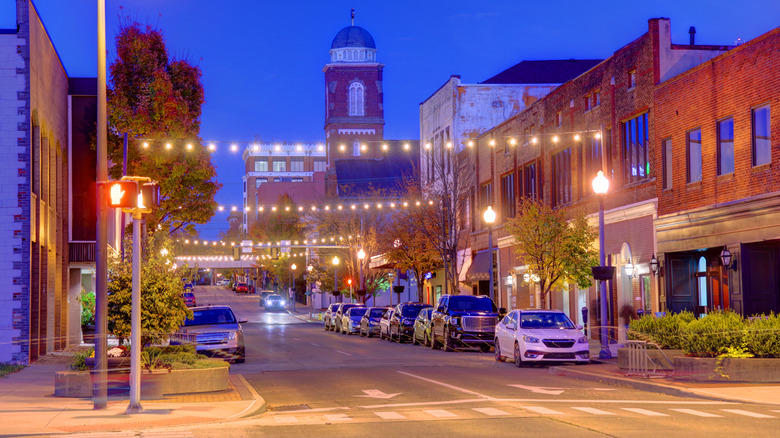 A dark blue sky over red buildings on a street filled with cars