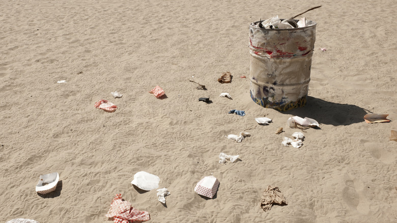 Trash can overflowing on the sand at Venice Beach in Los Angeles, California