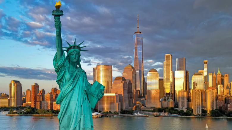 An aerial view of the Statue of Liberty and the New York City skyline at sunset