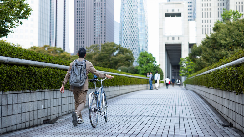 A man walking with his bike in Tokyo