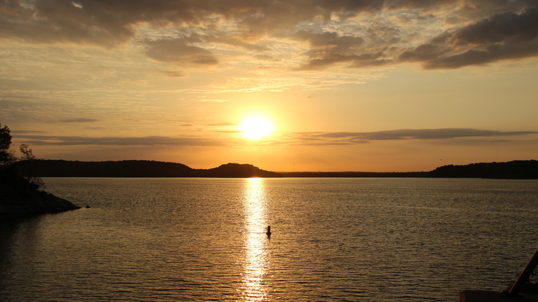 The sun sets over a wide expanse of Oologah Lake