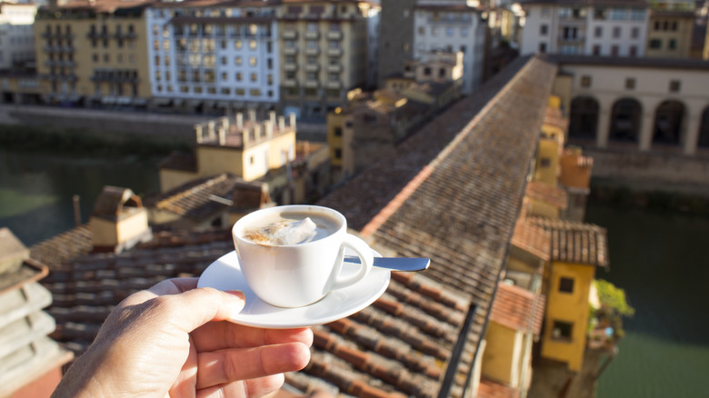 Someone holding a coffee at Ponte Vecchio
