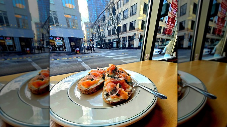 Salmon and cream cheese on toast looking out on the street