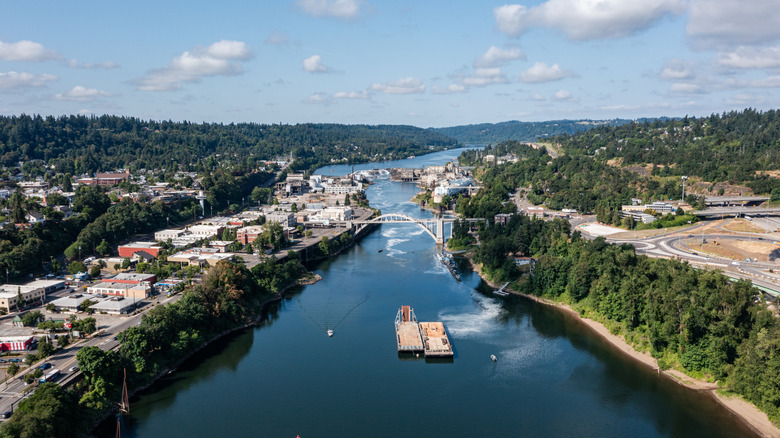 Oregon City Arch Bridge crosses Willamette River with trees and buildings on each bank