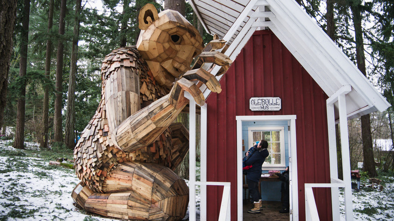 Ole Bolle the troll, a wooden sculpture at Nordia House, seen looking into a small schoolhouse