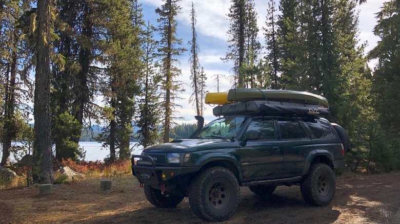 4WD with canoes on top on forest road Summit Lake