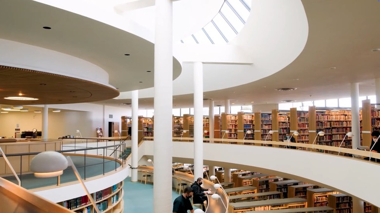Interior of Mount Angel Library in Oregon, rows of bookshelves and white pillars under skylight