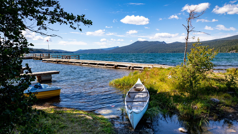 Odell Lake in Oregon, with a canoe on the shore and mountains in the distance