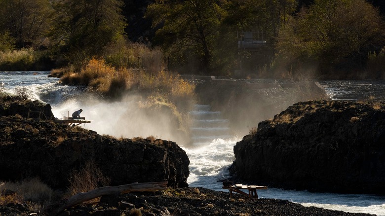 Indigenous person prepares to fish on the Deschutes River at Sherar's Falls. The picture was taken in Oregon in Autumn.