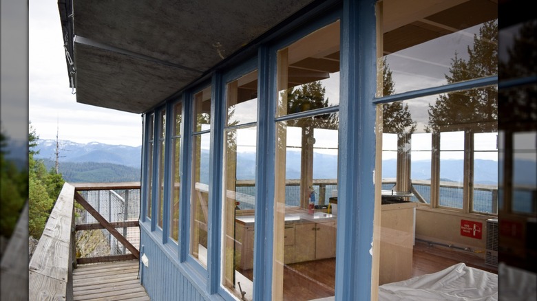 Acker Rock Lookout from the catwalk with the interior visible through the windows and mountains in the background