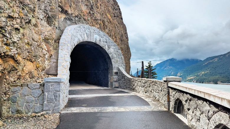 Tunnel pathway in rock with mountains in background