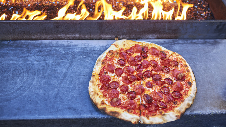A wood-fired pizza next to a fireplace