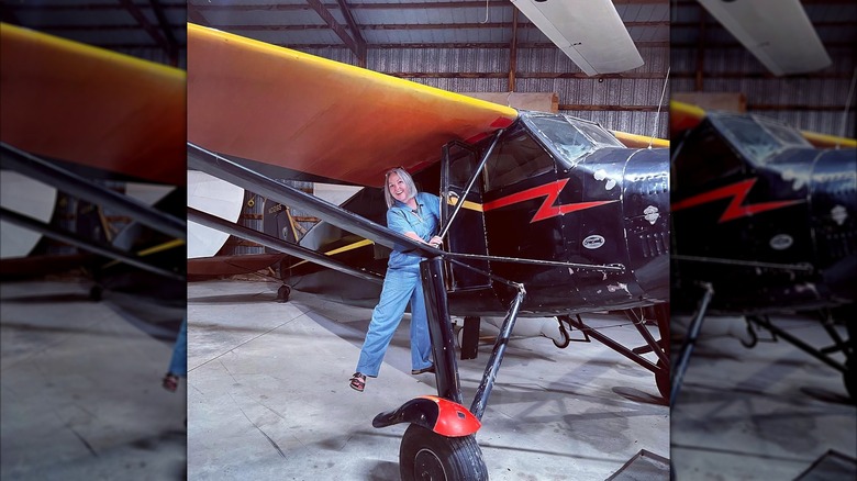 Woman posing with an antique plane at the Air Power Museum, Ottumwa, Iowa