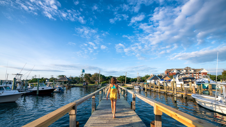Girl walks down a wooden dock in Ocracoke village
