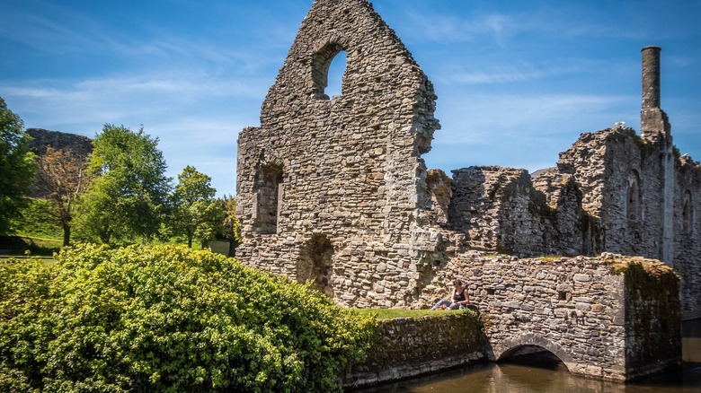 Stone Norman house ruins surrounded by lush shrubbery