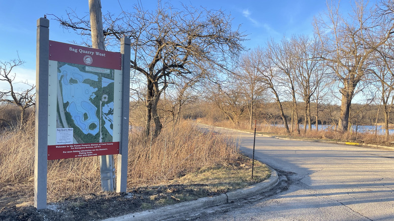 A map and bare trees mark the entrance to Sag Quarries