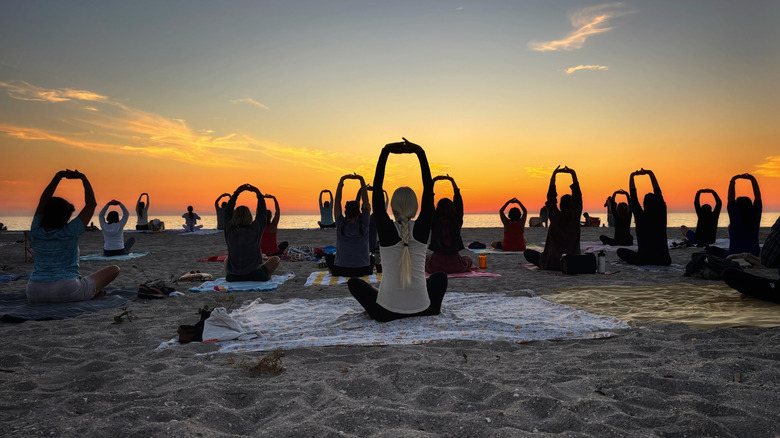 People doing yoga on the beach at sunrise on Englewood Beach, Florida