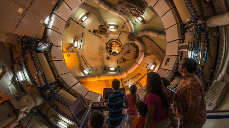 A family looks at the inside of a spaceship at a space center