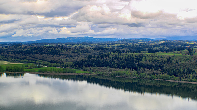 Aerial view of Crown Point area of Corbett, Oregon during the day with water, clouds, and trees in the background.
