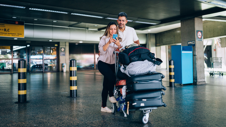 People with a luggage cart at the airport