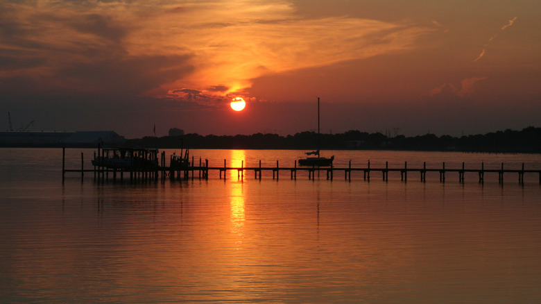 The sun setting over distant land over the North Bay in the Florida panhandle.