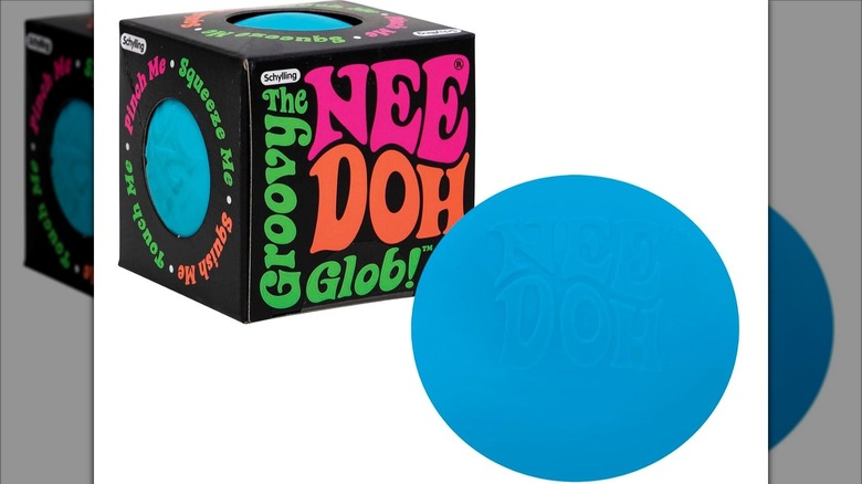 Blue NeeDoh ball next to its box.