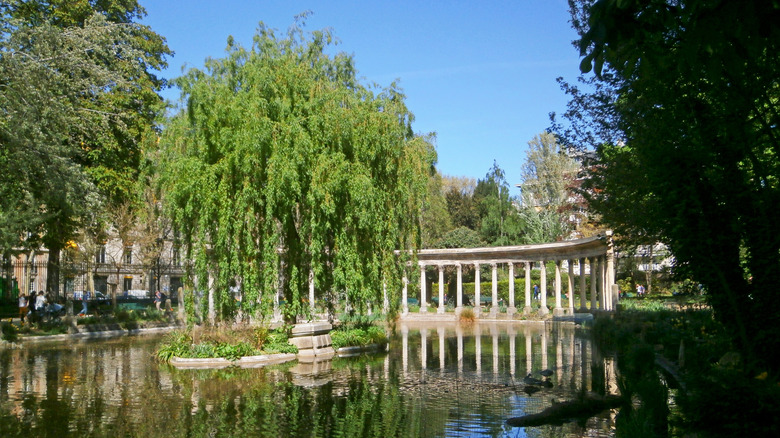 Scenic view of Parc Monceau, with trees, the colonnade, and water