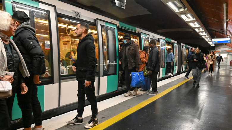 Passengers board a subway train in Paris