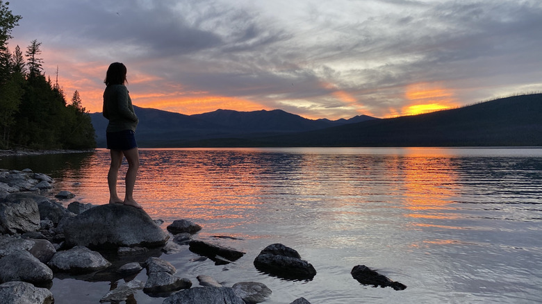 A woman's silhouette against Lake McDonald at sunset at Sprague Creek Campground