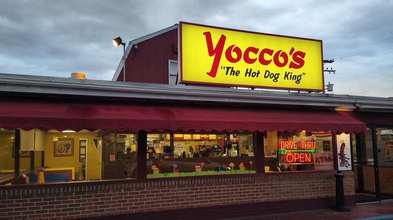 The exterior of a Yocco's restaurant with bright yellow and red signage and a classic diner atmosphere