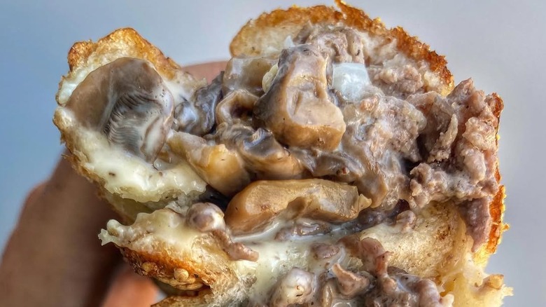 A close-up of a gooey Philly cheesesteak sandwich at Angelo's Pizzeria in Philadelphia