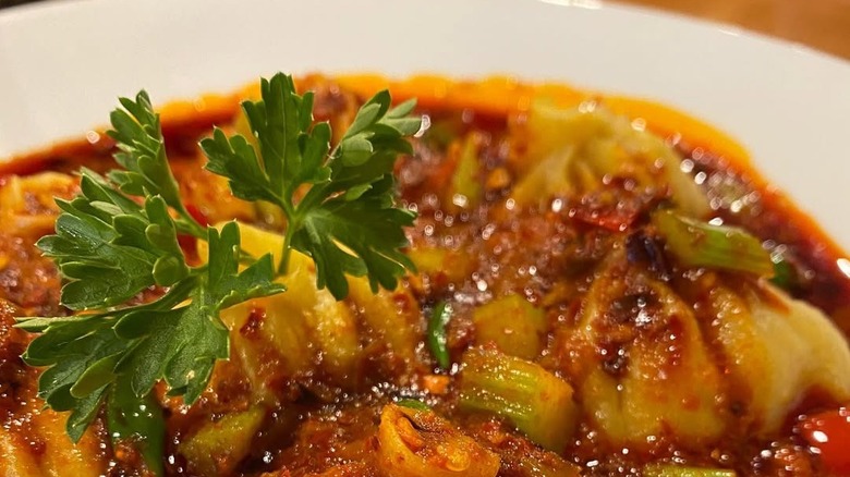A plate of momo dumplings in a rich spicy sauce at the White Yak Tibetan restaurant in Philadelphia