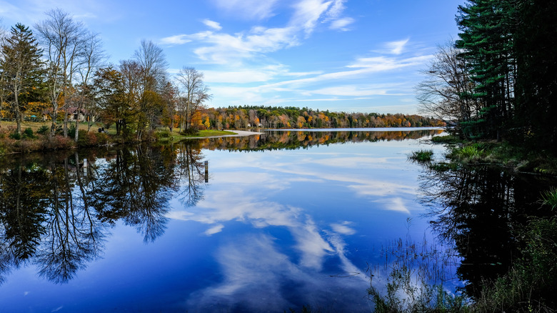 Pennsylvania lake with clear blue water reflecting the sky, surrounded by autumn trees