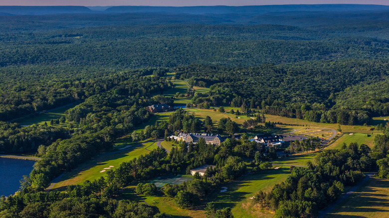 A drone view of Skytop Lodge and its vast 5,500 acre grounds with forest, a lake, tennis courts, and golf course