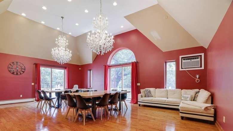 Interior of the dining room, filled with tables, couches, and chandeliers above, at the Majestic Secluded Castle, in Mount Poconos, Pennsylvania