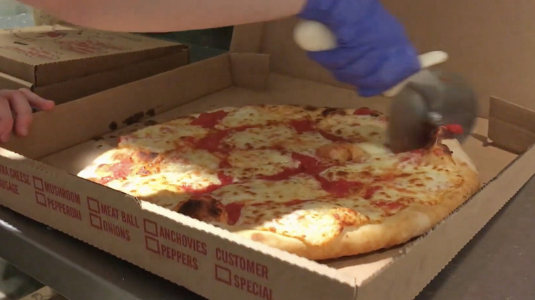 pizza in a box being cut