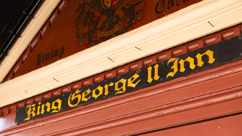 "King George II Inn" written in yellow letters on a black-and-red sign