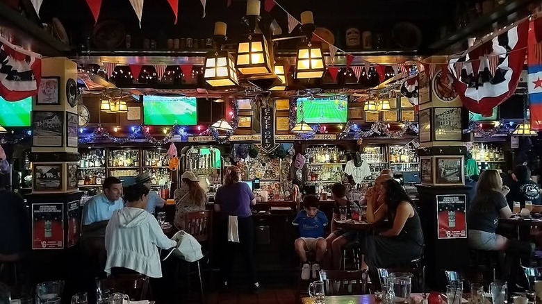 The bar inside McGillin's Olde Ale House with drinkers and TV screens
