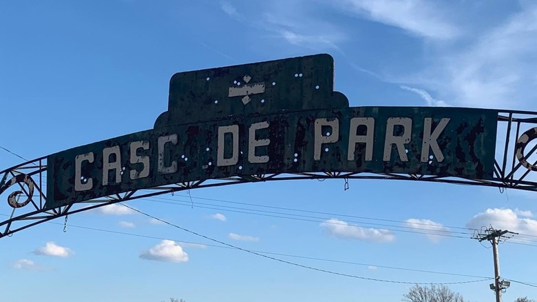 Sign of old Cascade Park entrance sign against blue sky.