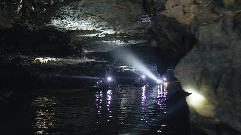 Boats queue up inside Penn's Cave, guided by floodlights.