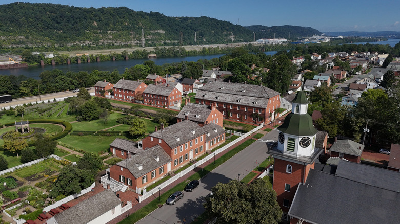 Aerial view of Ambridge, with brick buildings around a green lawn with the Ohio River in the background