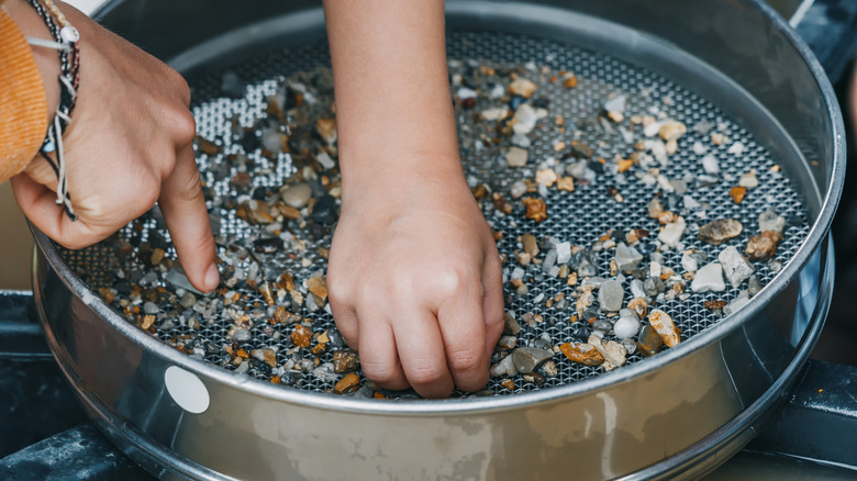 Child's hand panning for gems