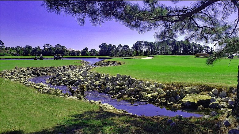 Vibrant green Tiger Point Golf Club with rock stream running through the course.