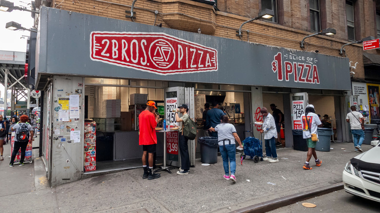 2 Bros. Pizza facade with people standing outside