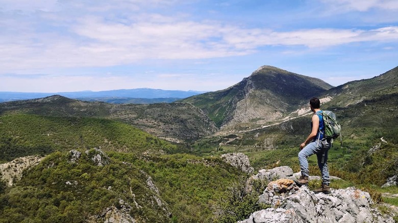 Hiker enjoying panoramic views in Le Hameau du Poil, France
