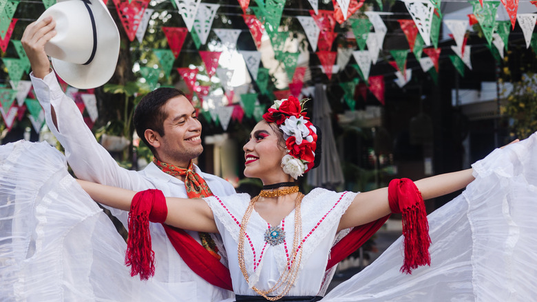 Man and woman smiling at each other while doing traditional Mexican dance
