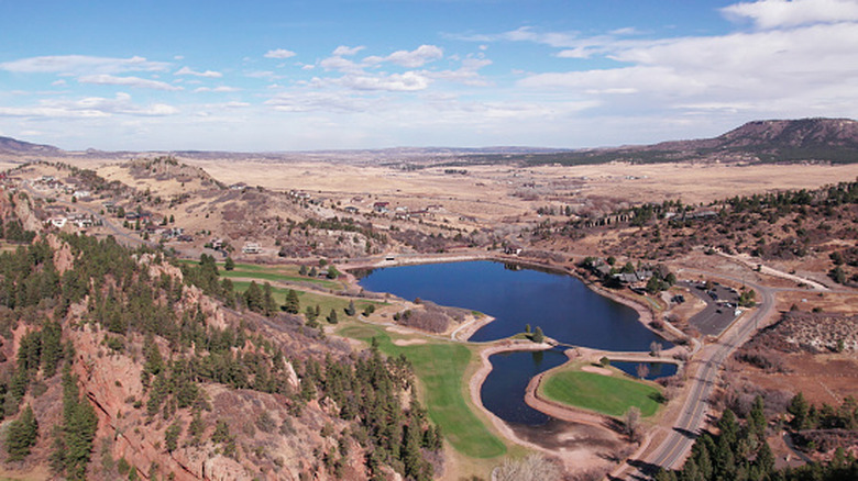 aerial view of lake and golf course surrounded by red rocks in Colorado