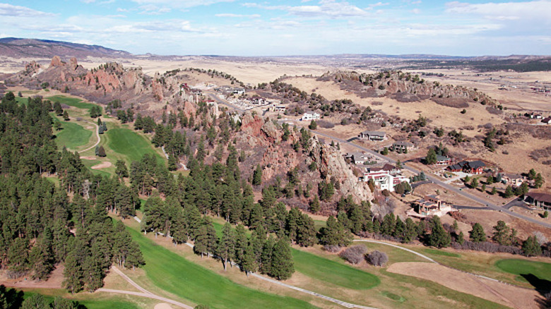 red rock formations and homes seen from a distance in Larkspur, Colorado
