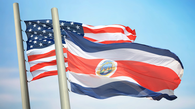 The American and Costa Rican flags against a blue sky